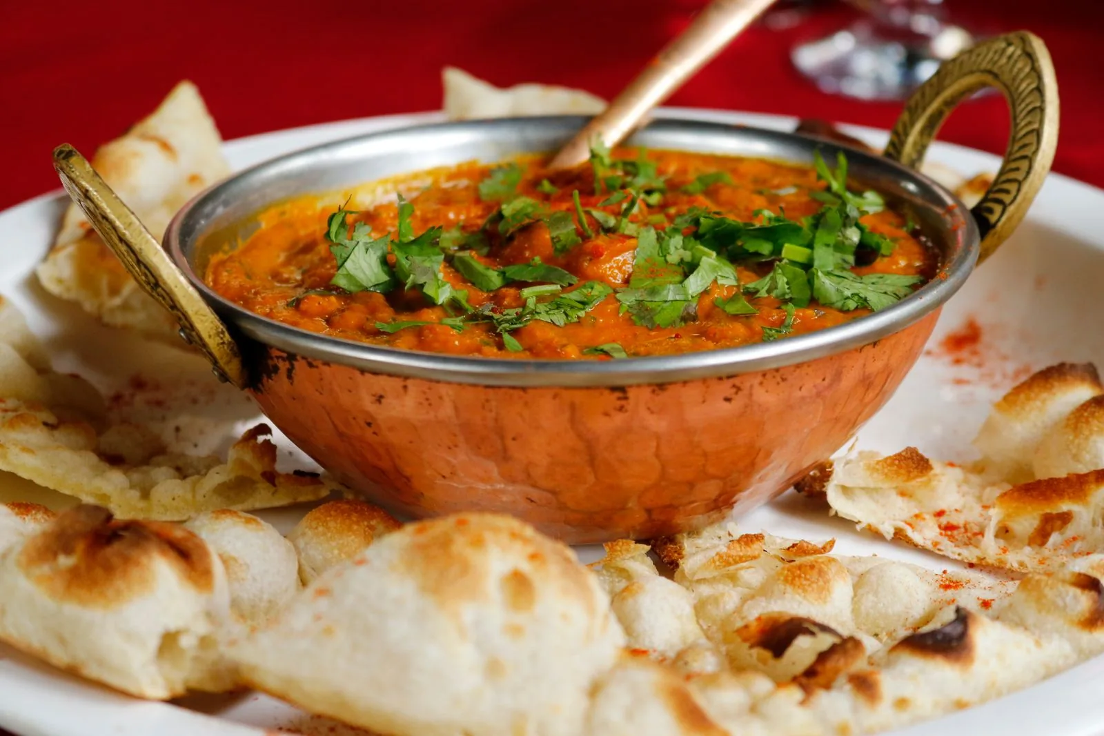 A balti curry served in a copper karahi with naan