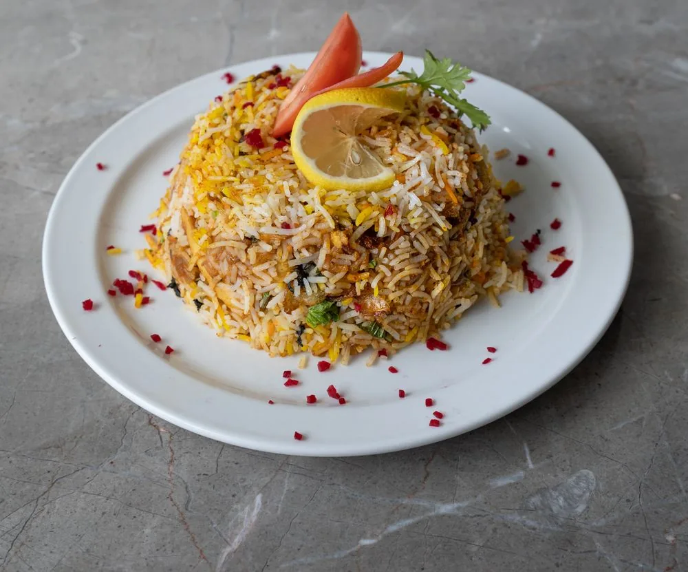 Fragrant biryani mound garnished with lemon