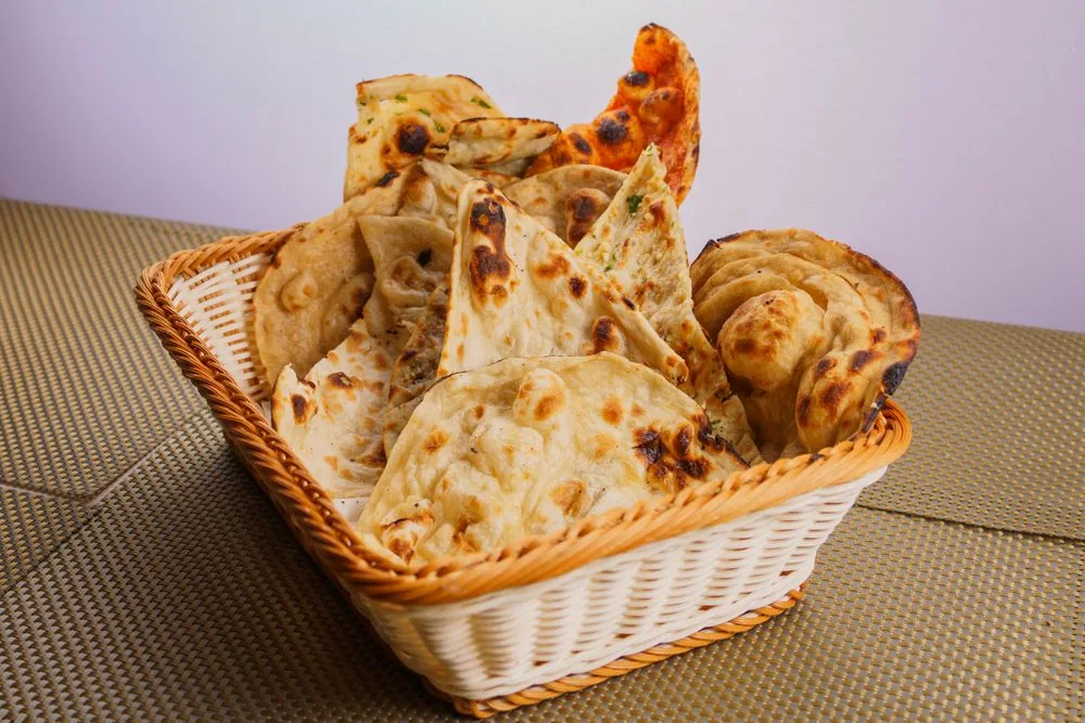 A basket of freshly baked naan breads